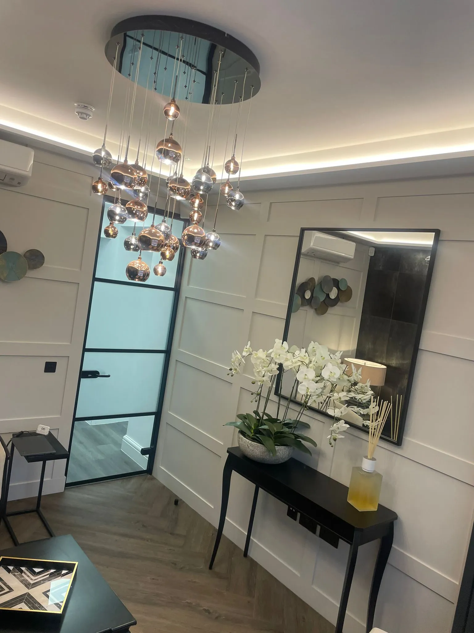 Panelled walls and feature mirror in the phase two lounge at Infinity Dental Clinic, Leeds