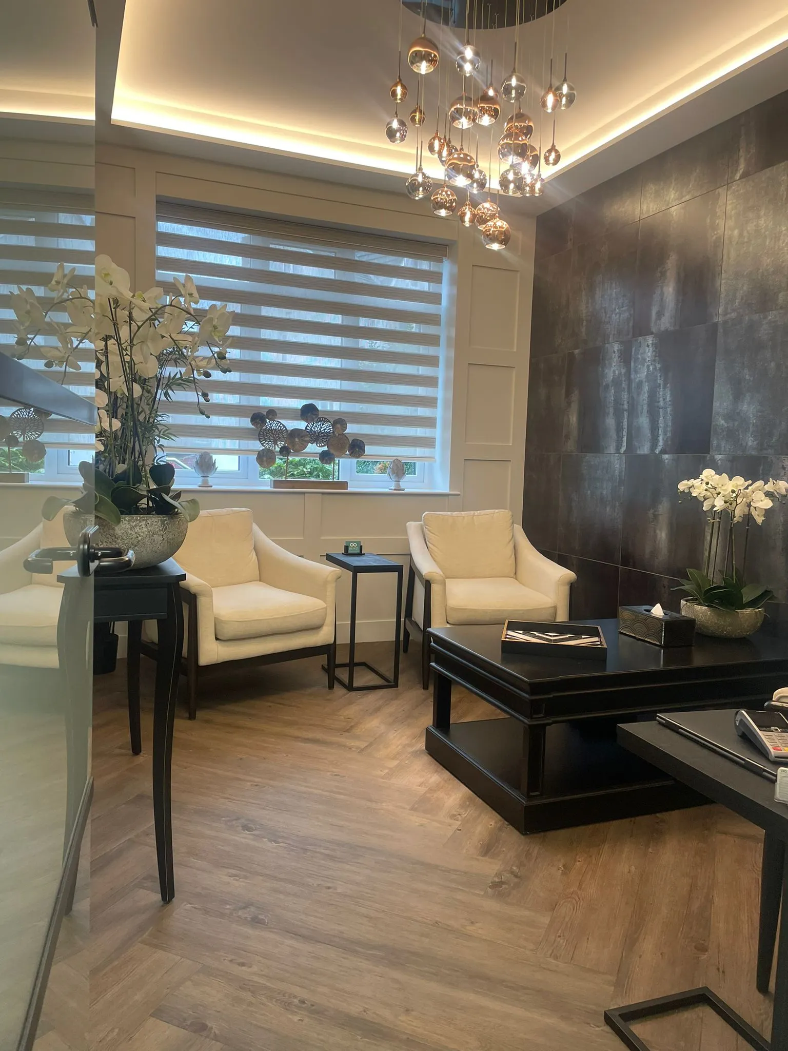 Cream armchairs and dark feature wall in the waiting lounge at Infinity Dental Clinic, Leeds
