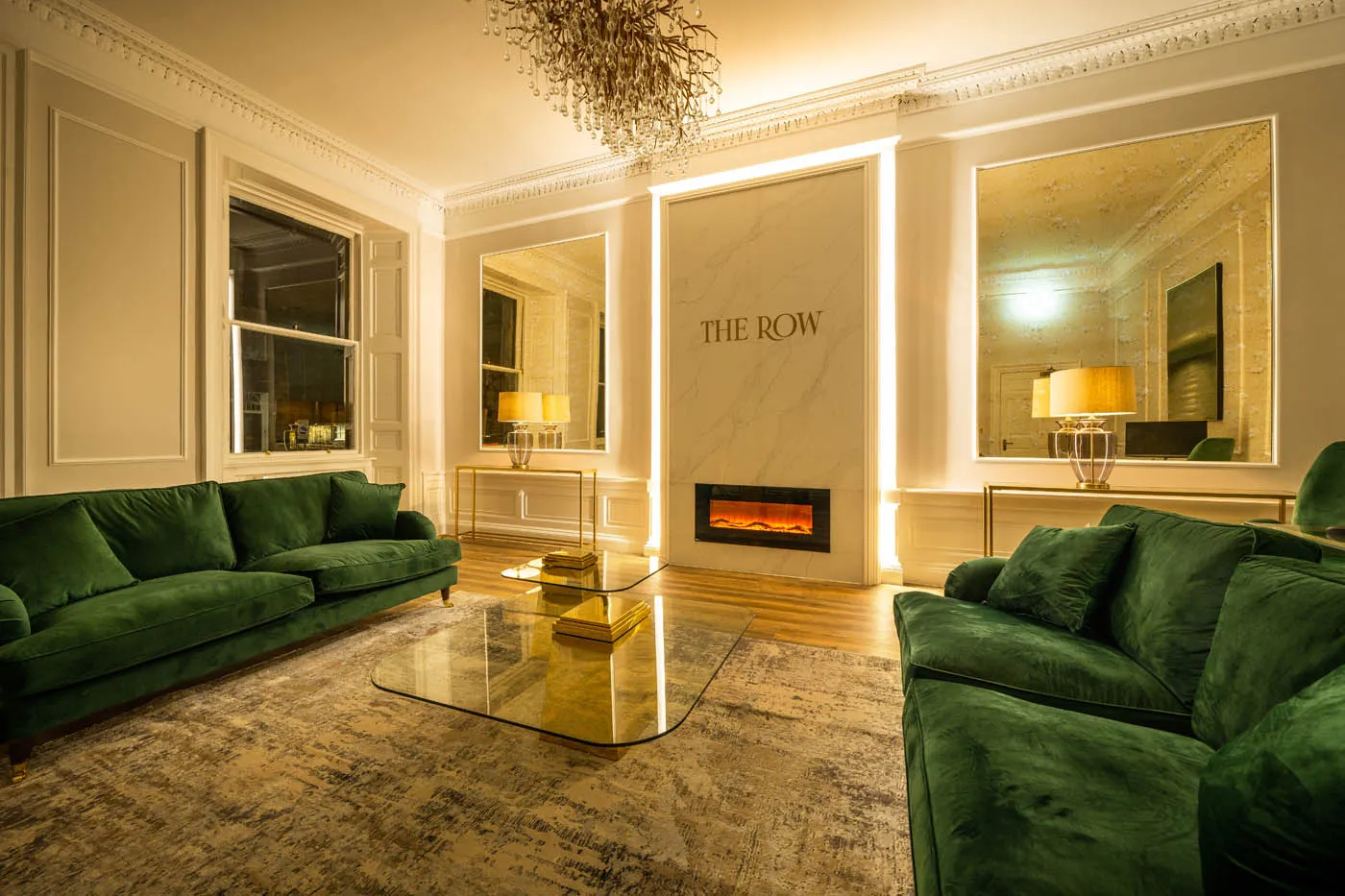 Emerald velvet sofas either side of a fireplace at The Row, Edinburgh