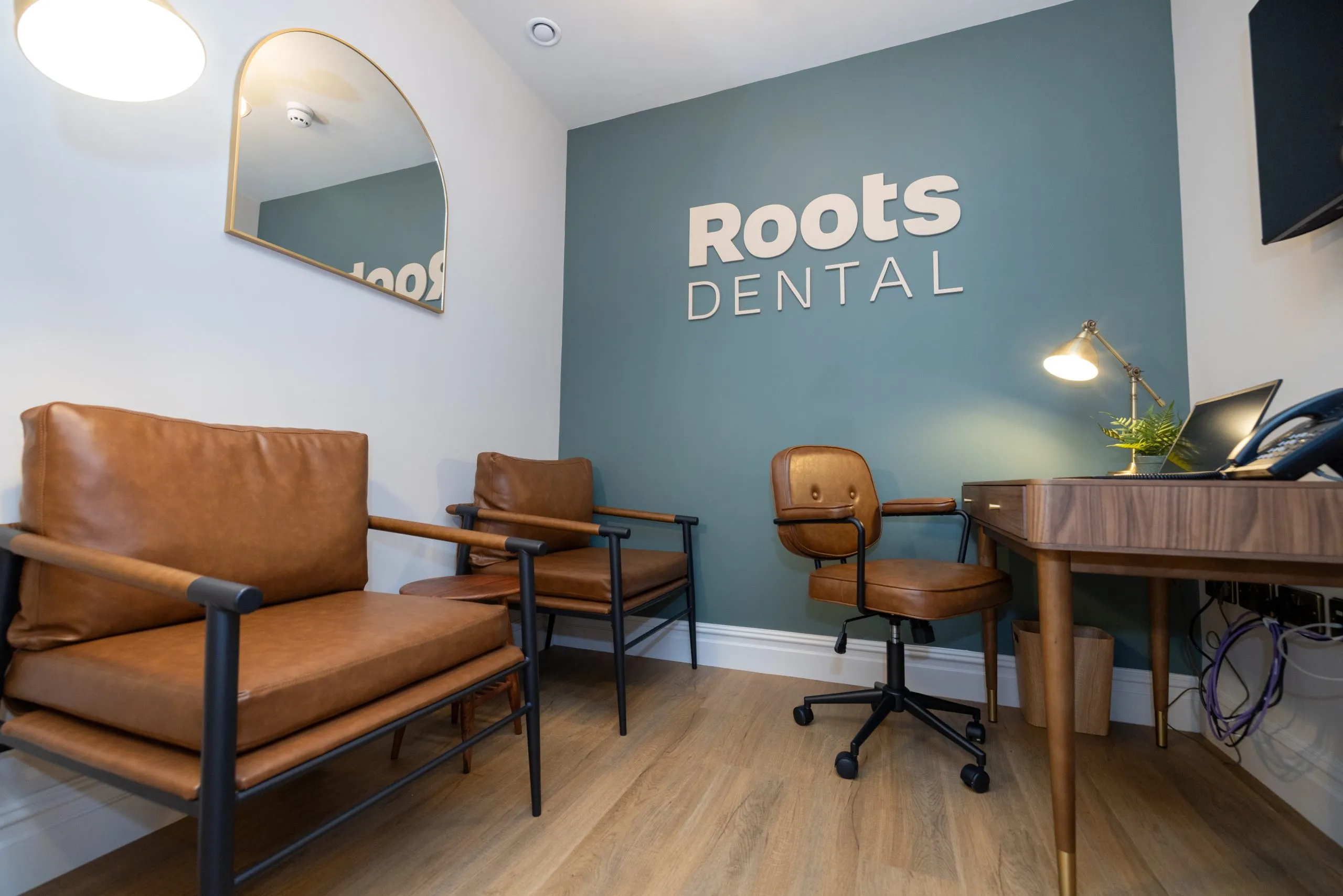 Consultation room with leather chairs and writing desk at Roots Dental, Morpeth
