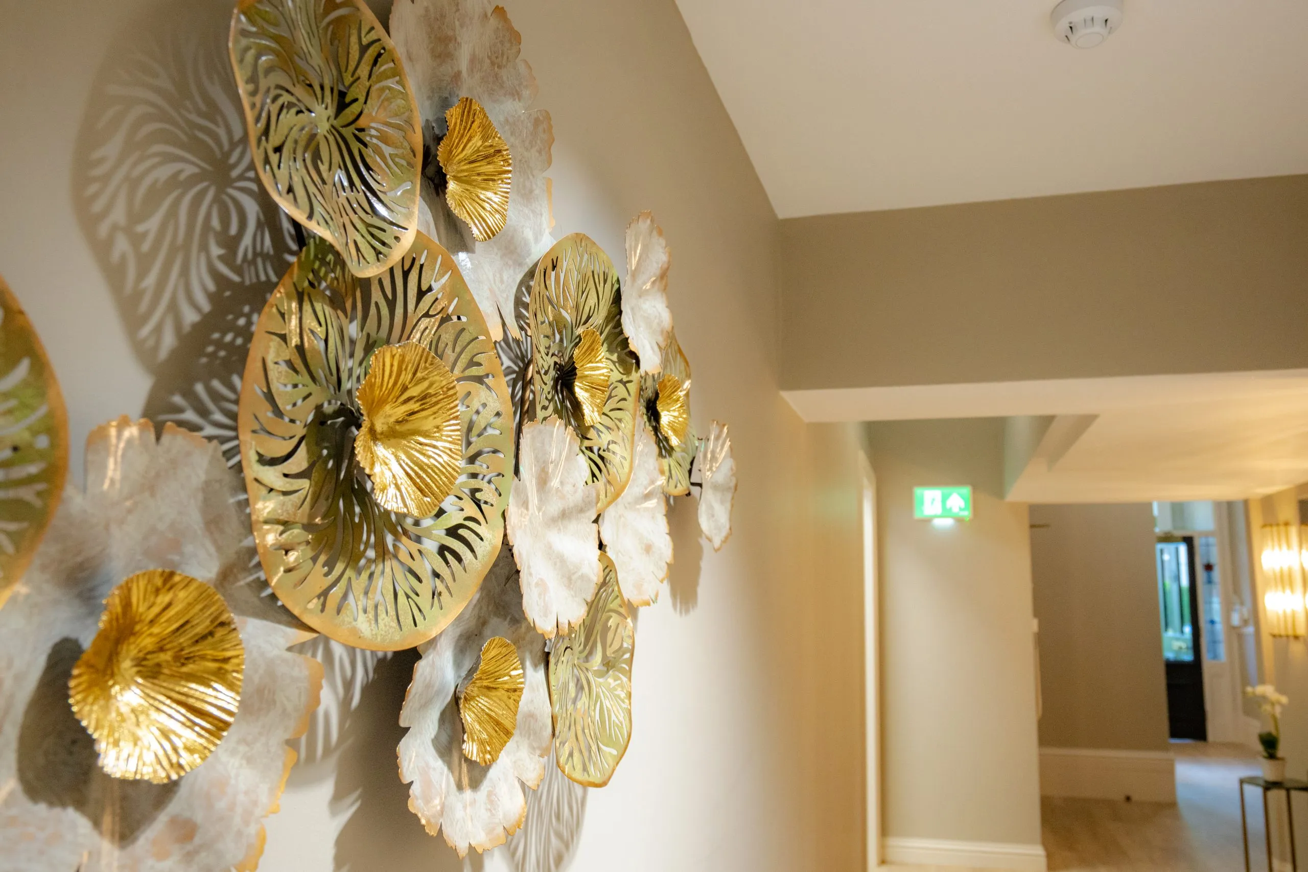 Gold botanical wall art in the corridor at Alma Dental, North Shields