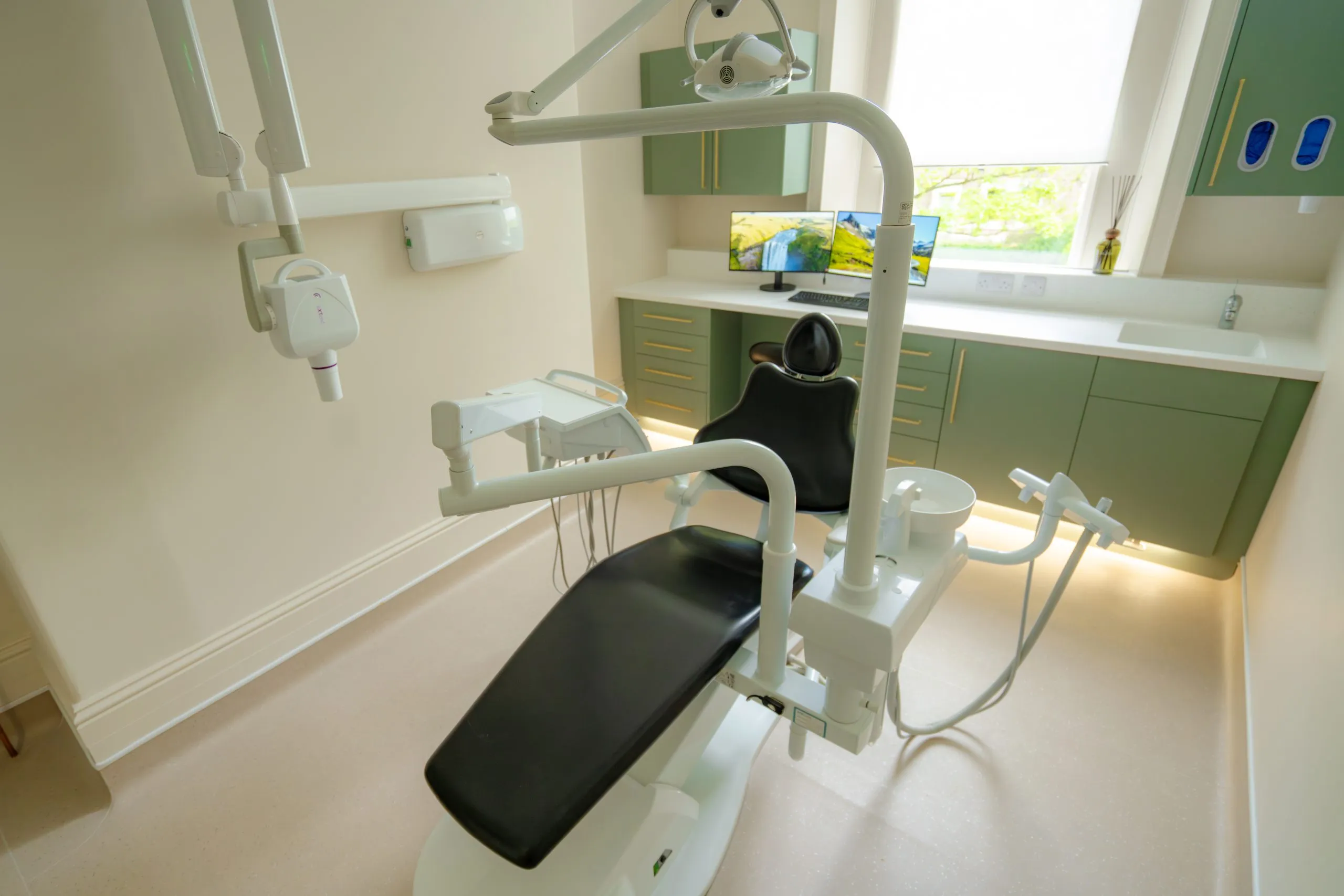 Compact dental surgery with green cabinetry and natural light at Alma Dental, North Shields