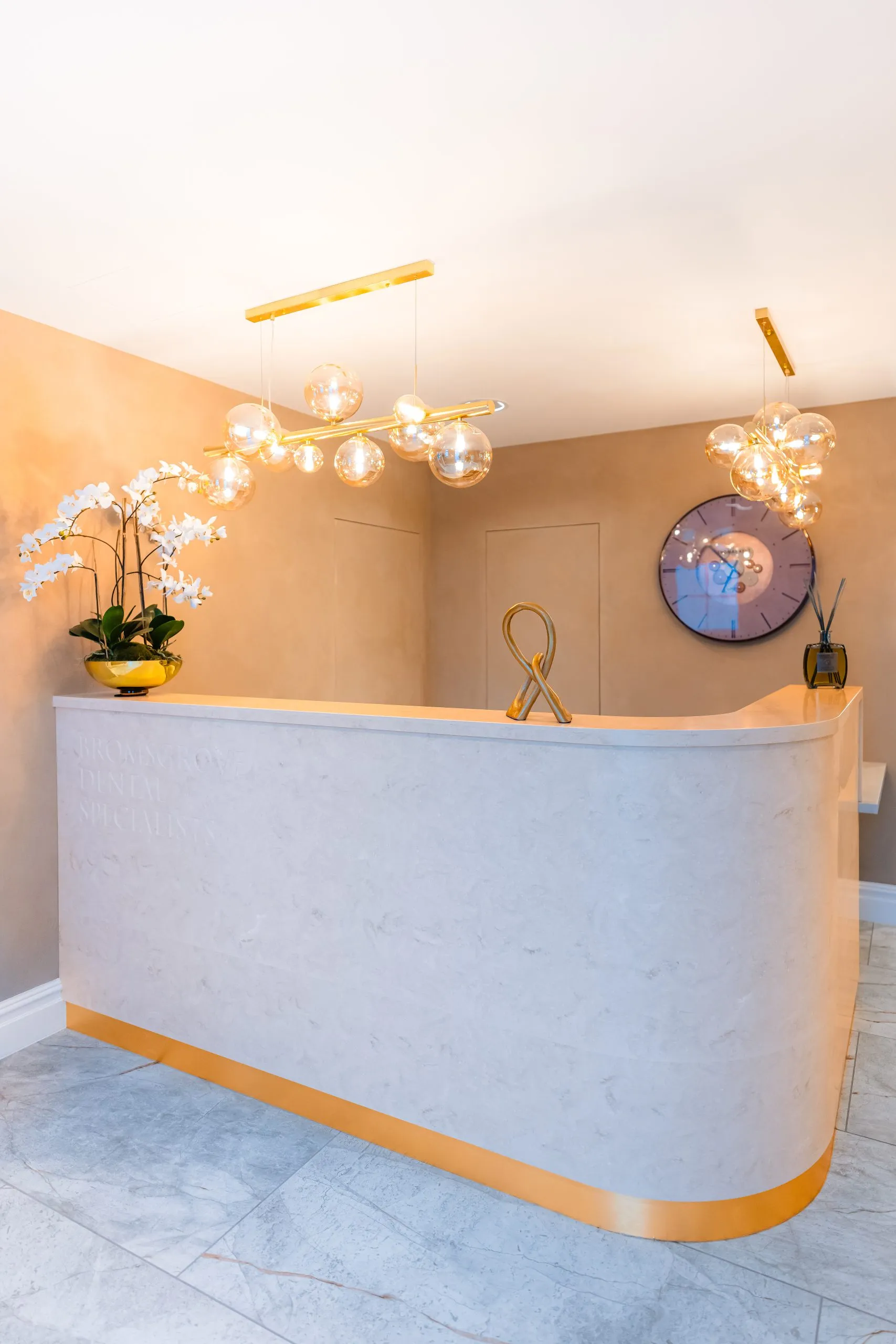Curved stone reception desk with orchid display at Bromsgrove Dental Specialists