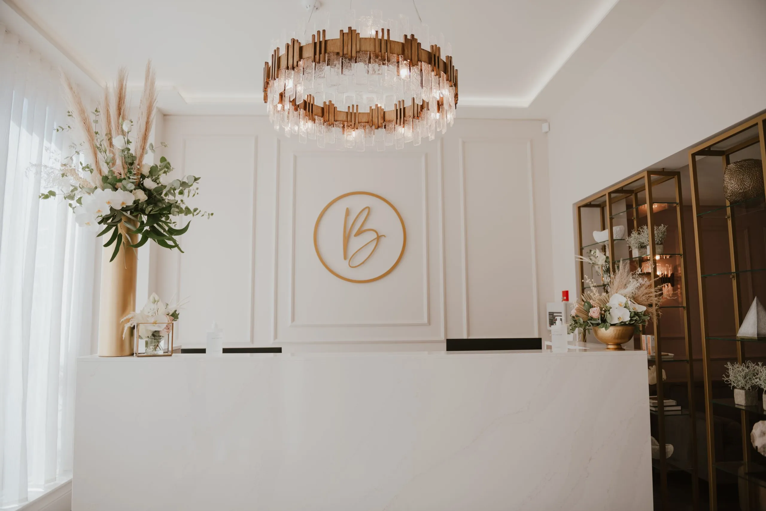 Monogrammed reception desk and statement chandelier at Blossom Cosmetic Clinic, York