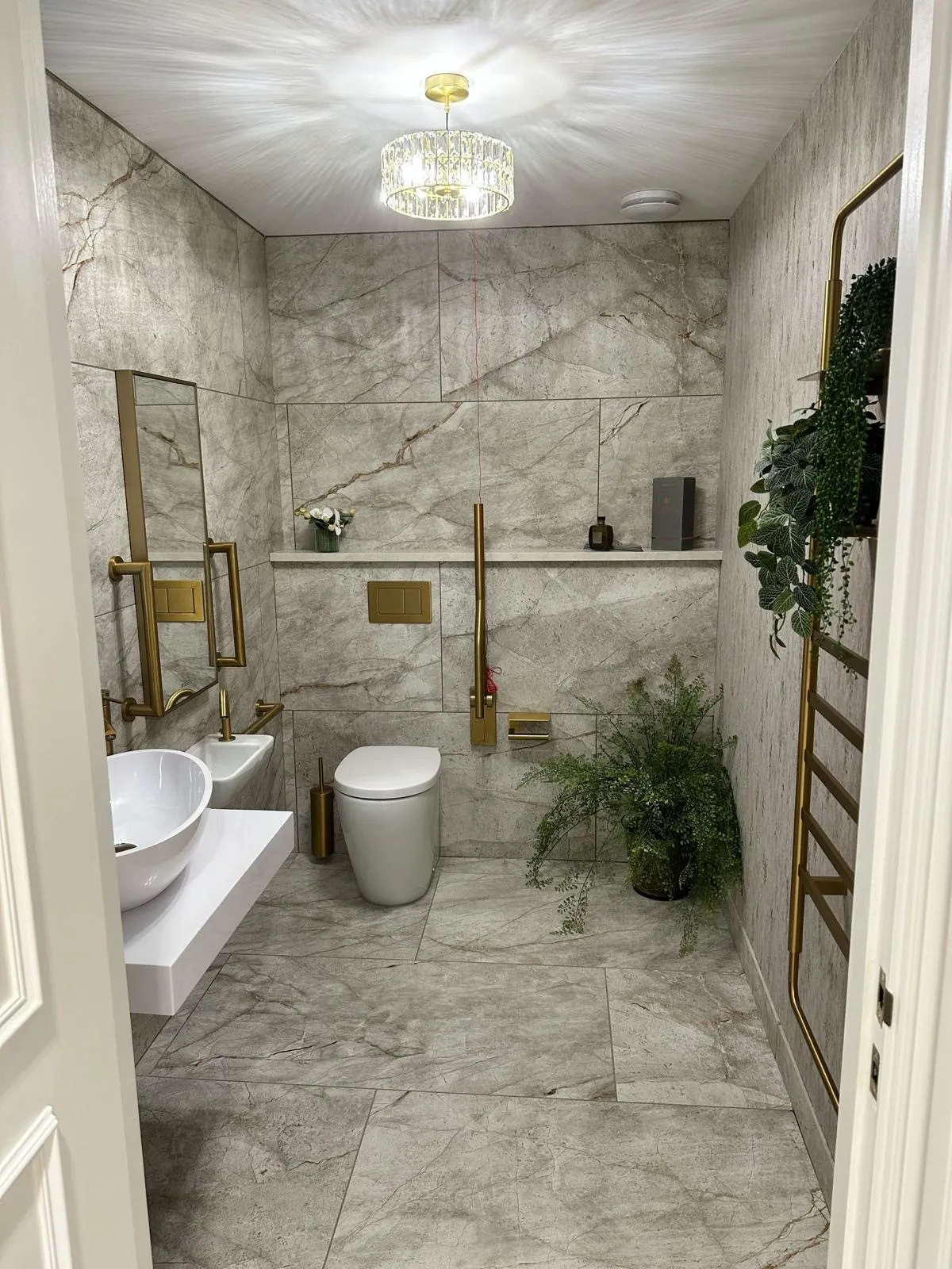 Accessible patient washroom with marble tiling and brass grab rails at Bromsgrove Dental Specialists