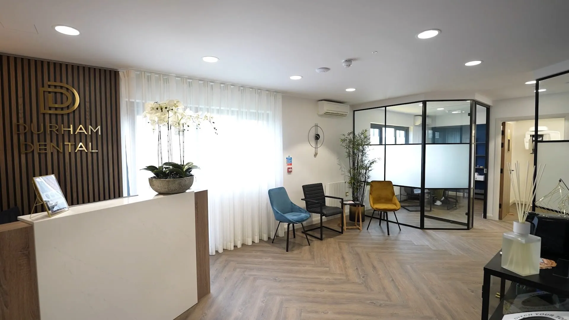 Reception with oak-slat feature wall and glazed partition at Durham Dental Implant Suite