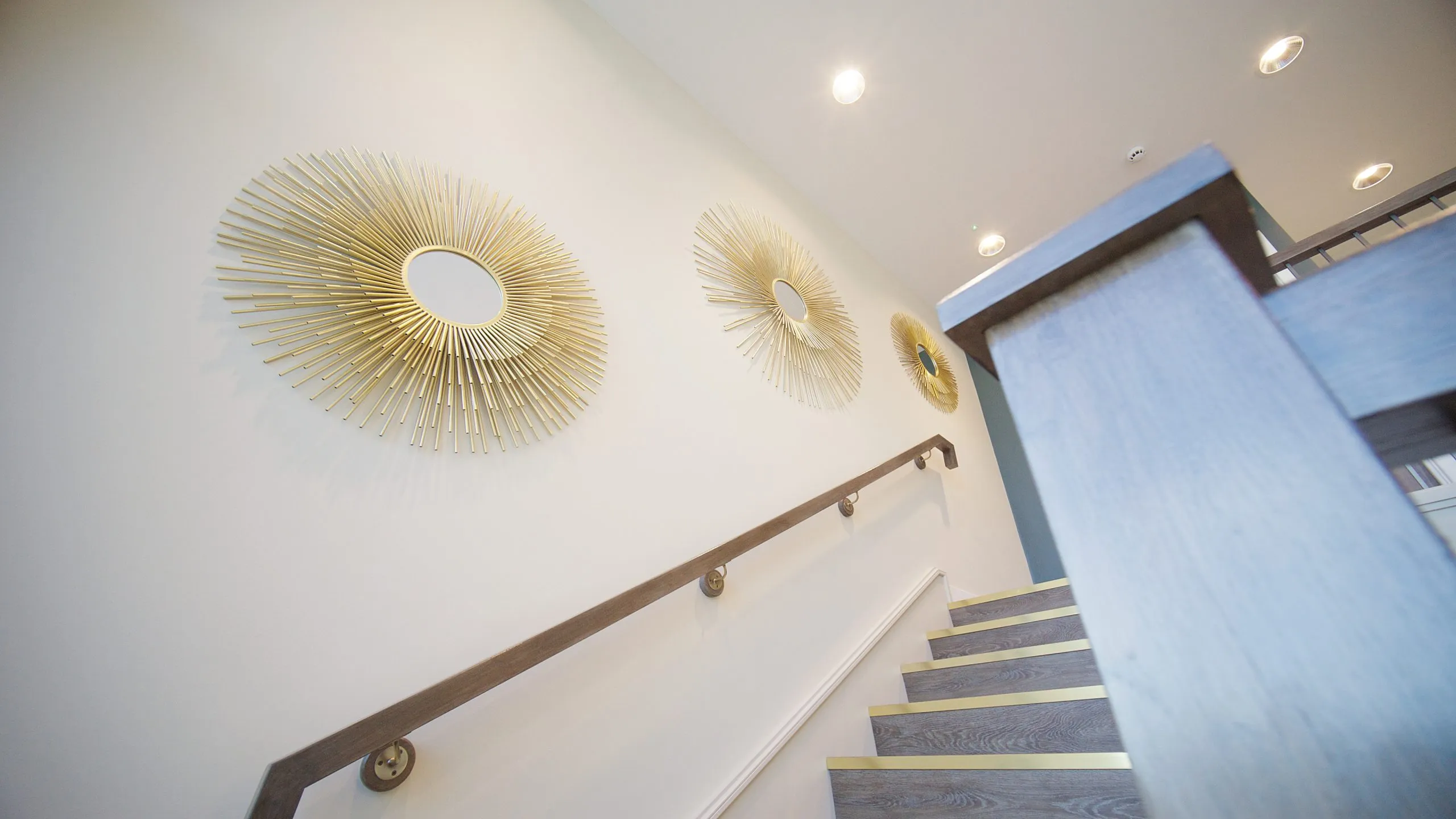 Gold sunburst wall art on the staircase at Infinity Dental Suite, Harrogate