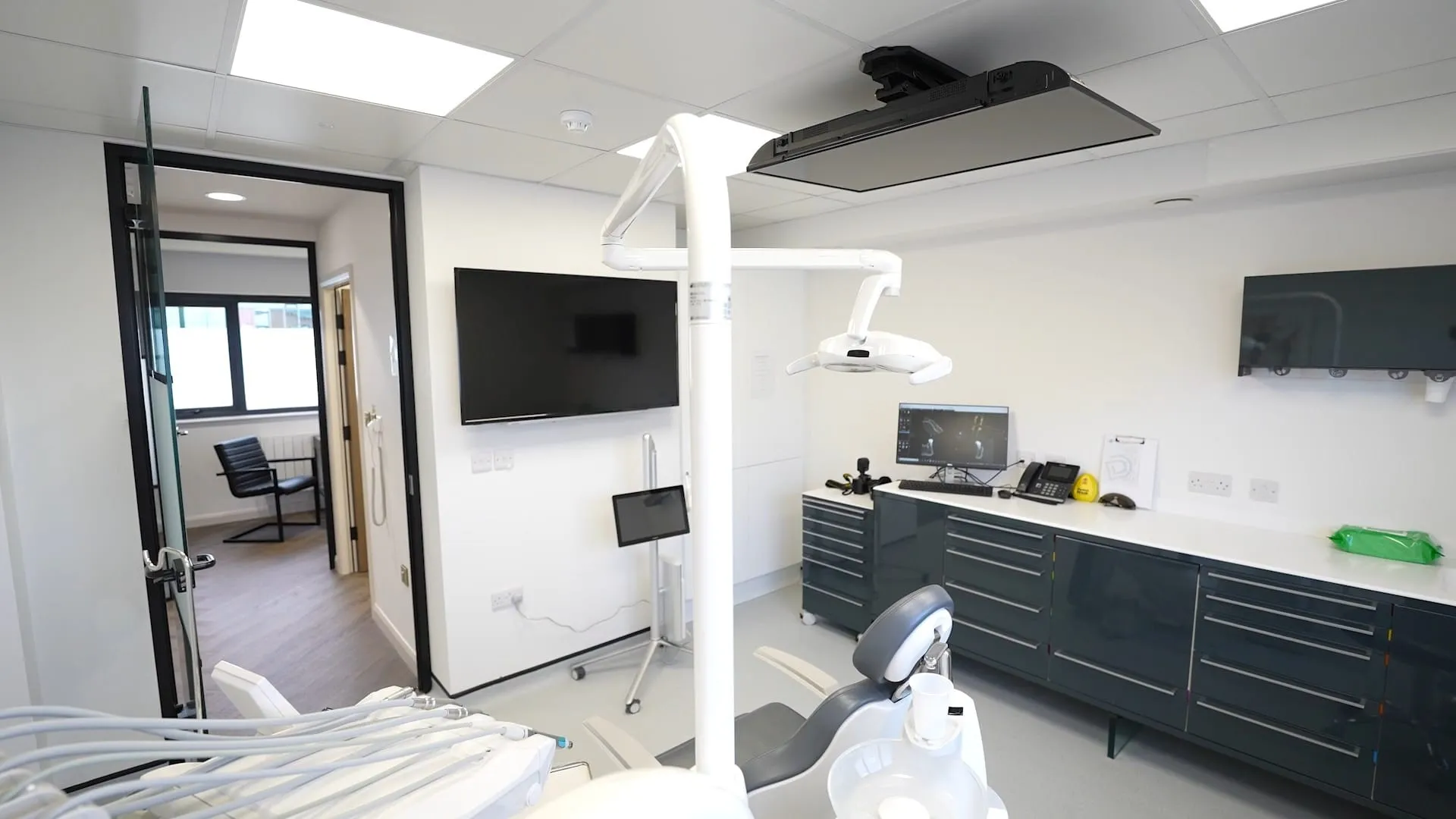 Treatment room with wall-mounted screens at Durham Dental Implant Suite