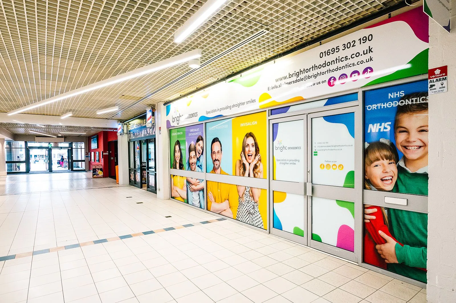 Shopping centre frontage with full-height branded graphics at Bright Orthodontics, Skelmersdale