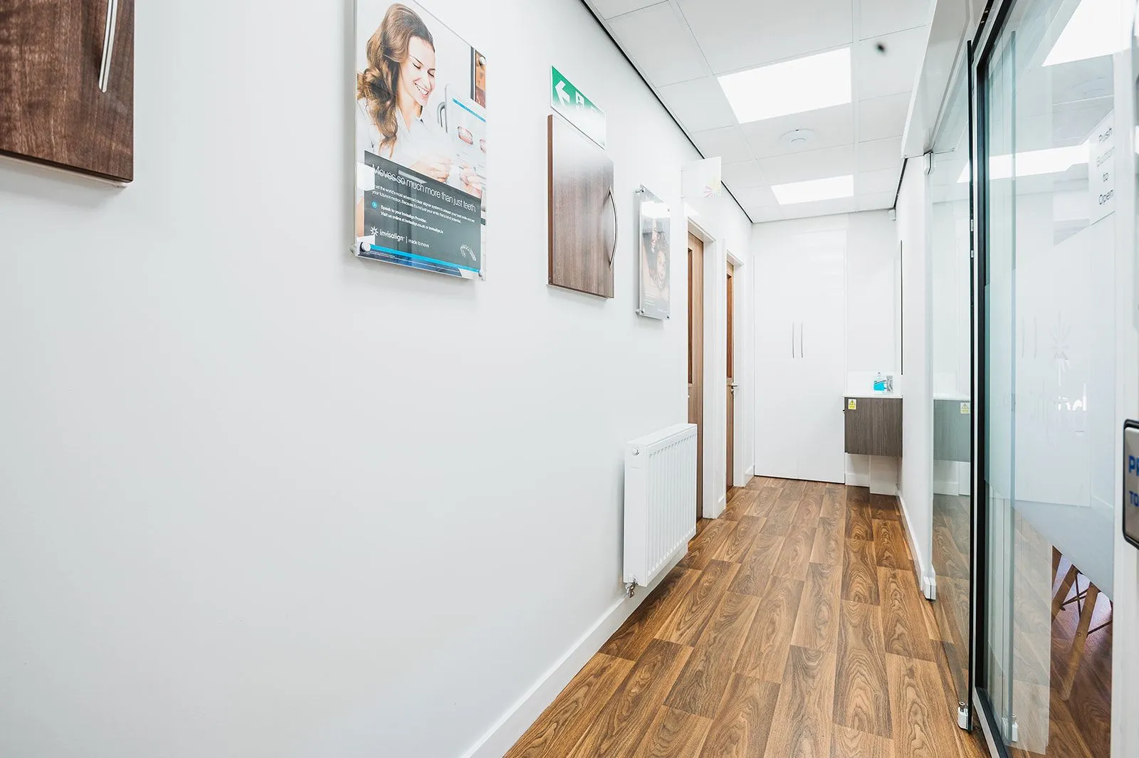 Corridor with glazed screens between surgeries at Bright Orthodontics, Widnes