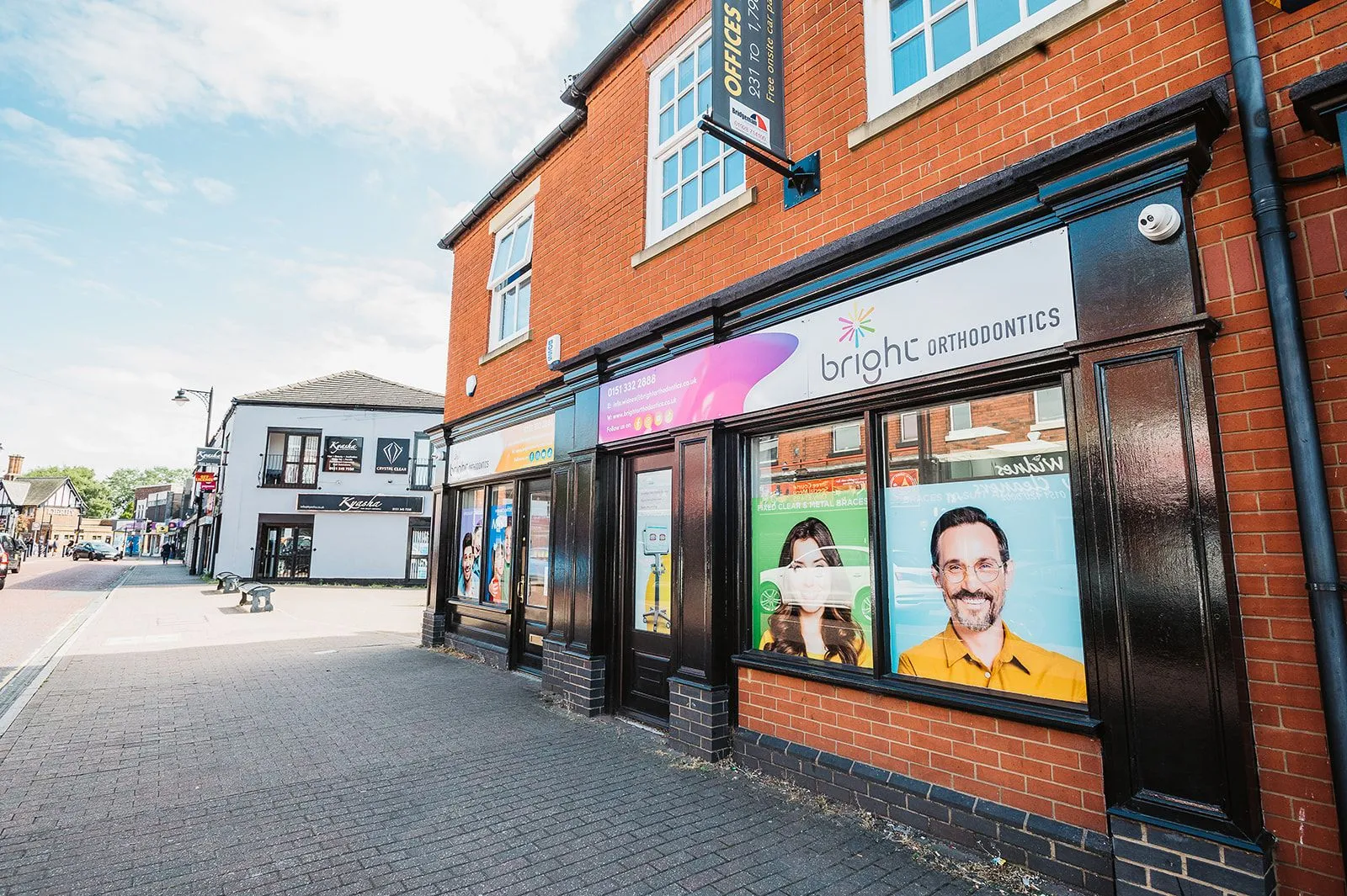 Terraced street frontage with branded windows at Bright Orthodontics, Widnes